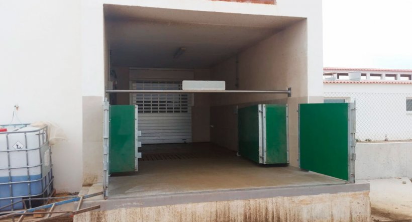 Imagen 6. Cargador semi-cerrado con puertas y barra horizontal para separar f&iacute;sicamente la zona sucia de la limpia. Cortes&iacute;a de Agropecuaria Los Girasoles, Espa&ntilde;a.
