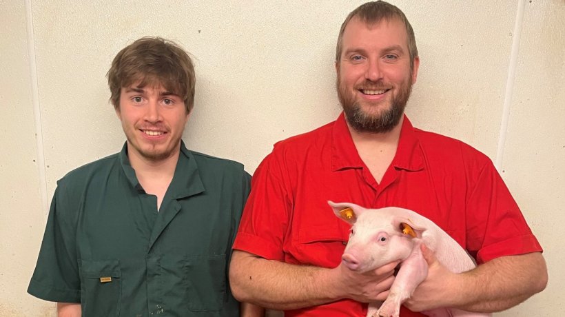 Brent McGhan (izquierda) y John Guikema de Snider Farms con Mitzi el cerdo n&uacute;mero 50 millones en Pigbase.
