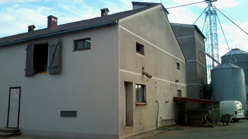 Figure 1: Bâtiment d'engraissement; bâtiment des truies reproductrices derrière dans la partie supérieure droite; porte d'entrée aux salles extérieures dans le mur.