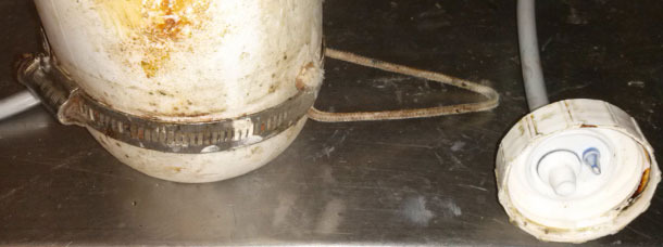 Una corda che passa sotto l'anello di metallo permette posizionare la bottiglia a testa in gi&ugrave; con un piccolo gancio.
