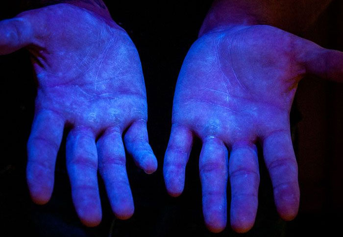 Foto 6. Materiale fluorescente a luce ultravioletta (UV) per dimostrare che il prodotto copre la totalit&agrave; delle mani. Fonte&nbsp;www.glogerm.com
