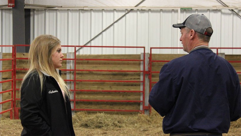 ISU student employee Michaela Friest talks with a potential buyer at the 2018 Tradition of Excellence sale hosted by ISU students at the Hansen Ag Student Learning Center.