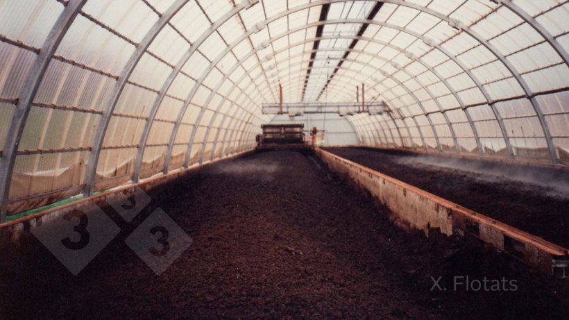 Figure&nbsp;2. Composting system in a greenhouse, to prevent humidification by rainwater and to control temperature, with mixing and aeration by means of a machine that circulates on rails on the side walls. The bulking material, which provides carbon and porosity, is wheat straw.
